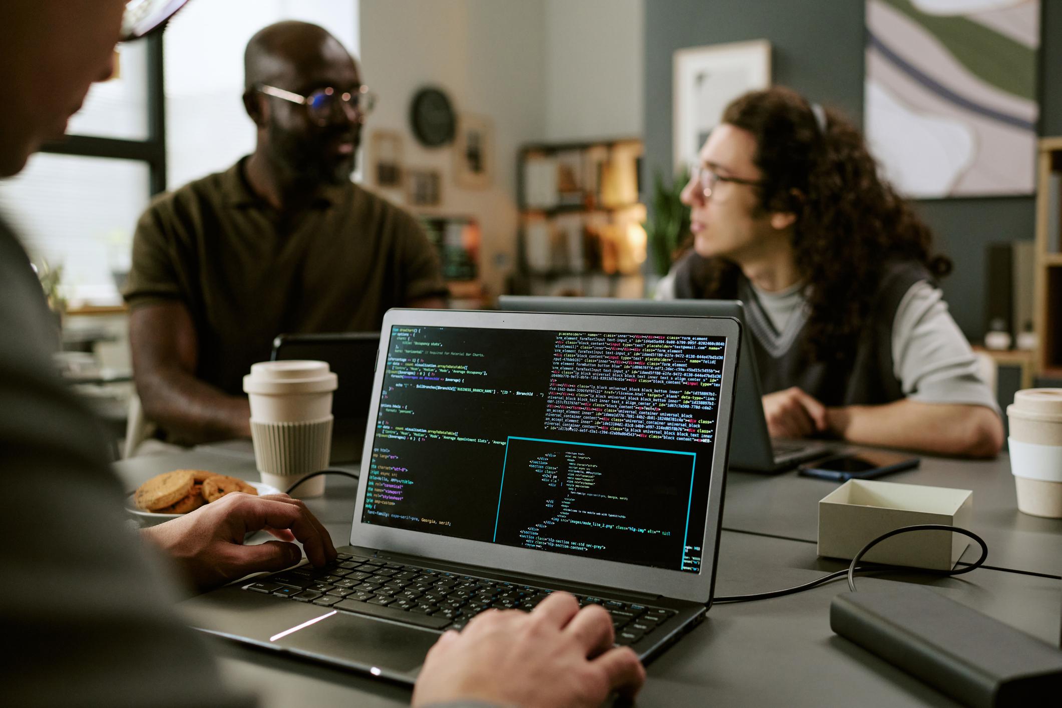 Designers and developers working together around laptops